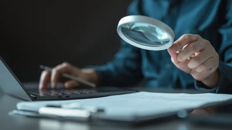 Entrepreneur checking data with a magnifying glass to assess evidence reliability