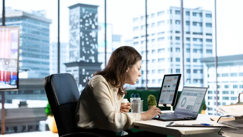 Entrepreneur analyzing charts on a laptop in an office, demonstrating core analytical skills in business decision-making